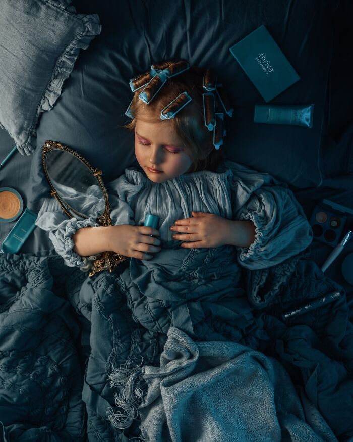 Child with curlers and mirror, sleeping peacefully, capturing the magic of childhood in a dreamy setting.