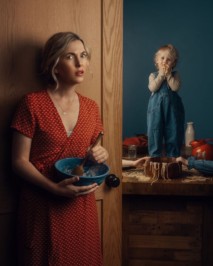 Mother with a mixing bowl and child playing with spaghetti, capturing childhood magic through a mother’s lens.