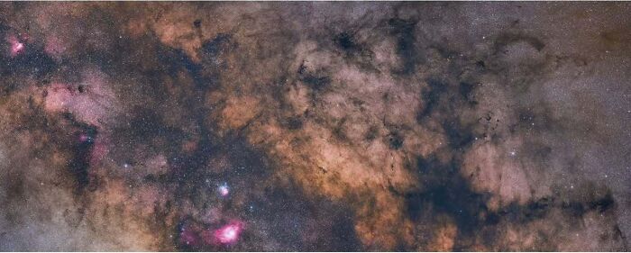 Astrophotography showcasing a colorful, starry night sky filled with cosmic clouds and nebulae.