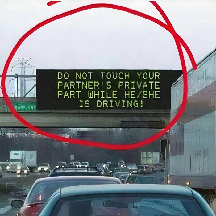 Highway sign with a humorous message to make your day better, advising against distracting your partner while driving.
