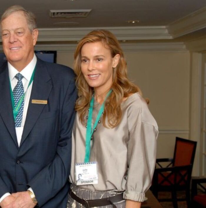 Two business professionals wearing conference badges, representing some of the richest people in the world.