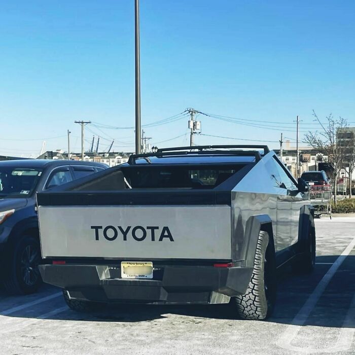 A truck resembling a futuristic vehicle with "Toyota" on the back, parked outdoors under a clear blue sky. A truck resembling a futuristic vehicle with "Toyota" on the back, parked outdoors under a clear blue sky.
