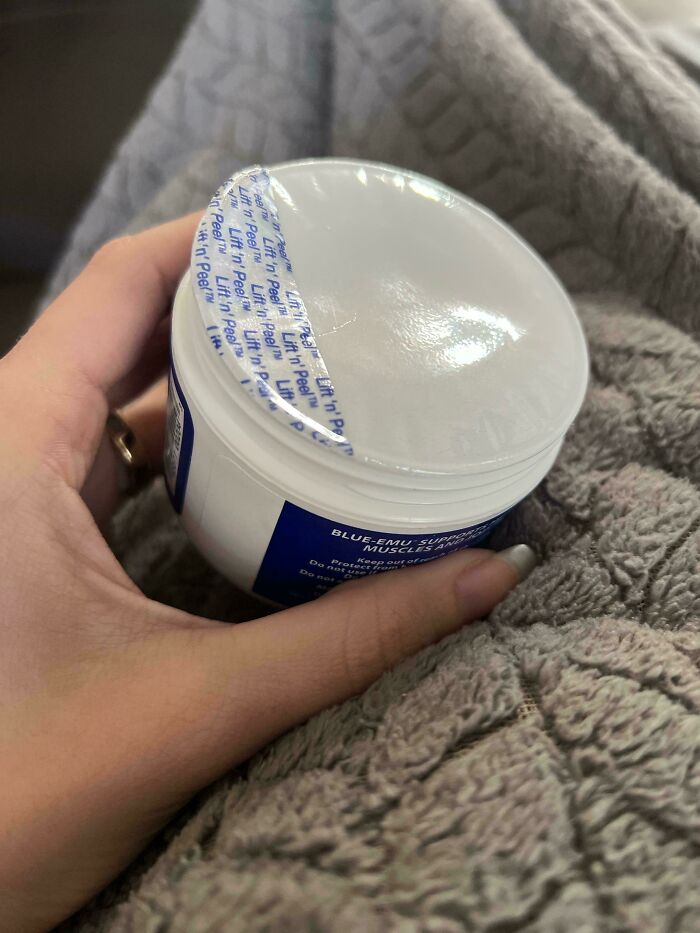 Hand holding a jar with an improperly sealed lid, showcasing a disastrous design flaw.
