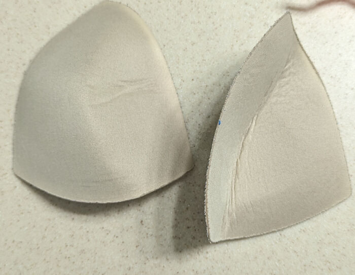 Two mismatched foam bra cups, part of disastrous design mistakes.