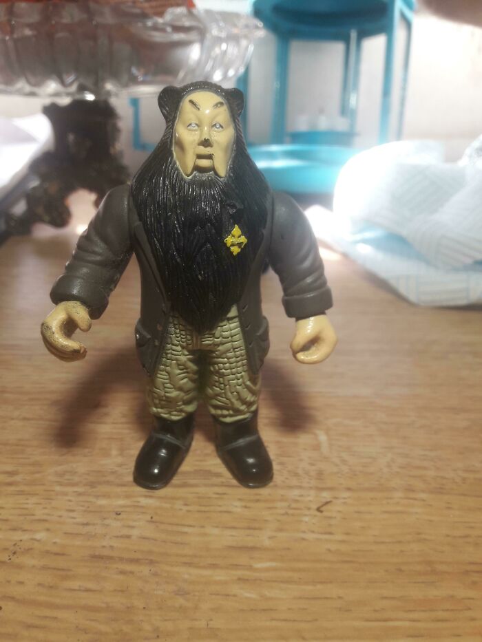 Strange toy figure wearing a suit with a yellow badge, an example of disastrous design.