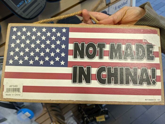 Sign with American flag stating "Not Made in China," contradicting the "Made in China" label, illustrating disastrous designs.