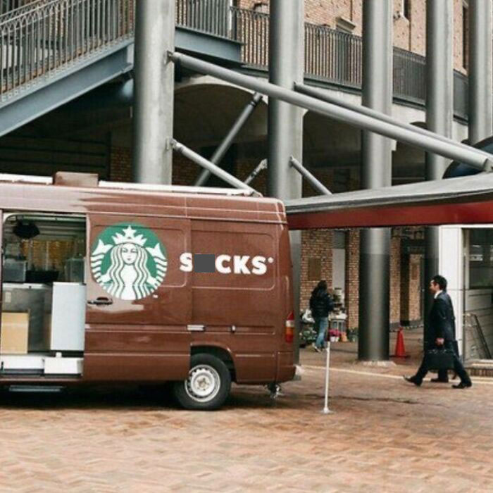 Brown van with humorous design mistake on the side in an urban setting.