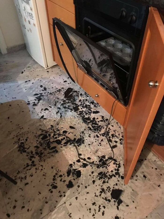 Oven door shattered with glass pieces scattered on the kitchen floor from poor decision-making.