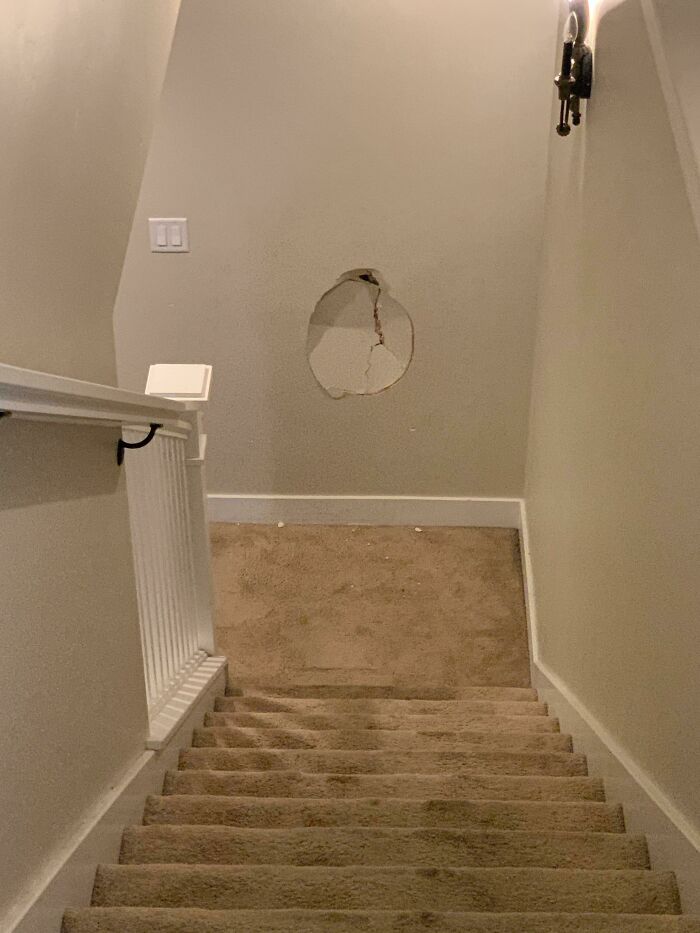 A hole in the wall at the bottom of a staircase, illustrating poor decisions in house design.