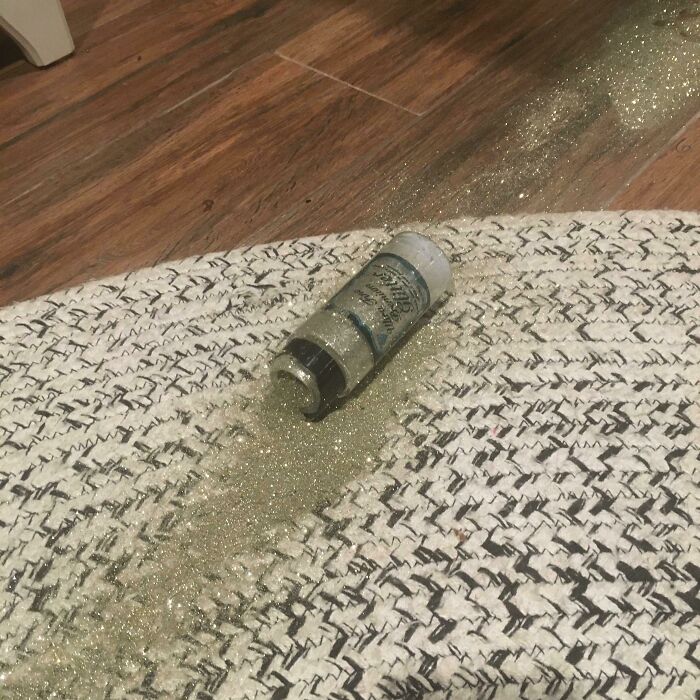 Glitter spill on herringbone rug and wooden floor, showing poor decisions in home decor mishap.