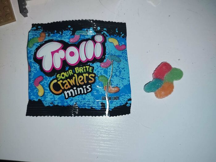 Trolli Sour Brite Crawlers Minis package and candy on a white surface.