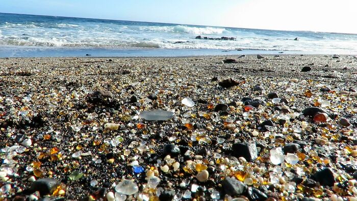 Colorful glass pieces on a beach, highlighting the exciting diversity of our world.