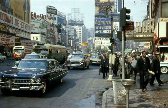 Times Square in the 1960s with vintage cars and bustling crowds, showcasing America during the JFK years.