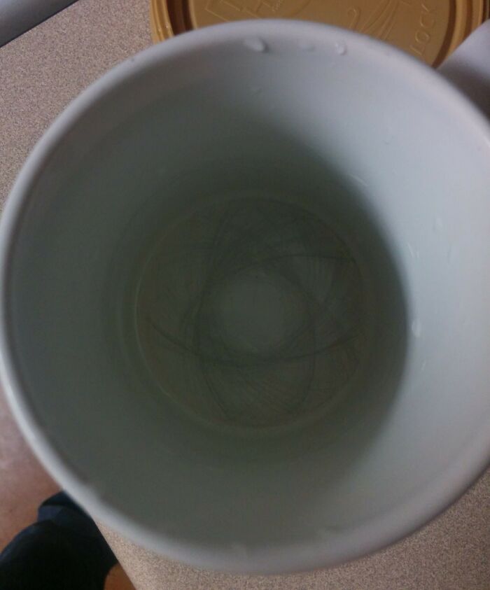 A ceramic mug with visible swirl patterns inside from repeated use over time.