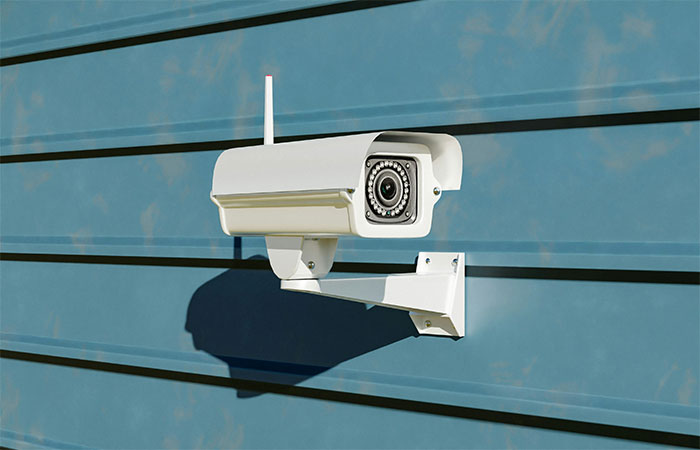 Security camera mounted on exterior wall to protect home against burglars. Security camera mounted on exterior wall to protect home against burglars.