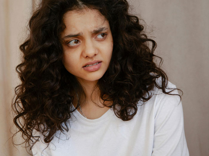 Woman expressing frustration after tasting a bland meal, emphasizing tensions over cooking preferences at work. Woman expressing frustration after tasting a bland meal, emphasizing tensions over cooking preferences at work.