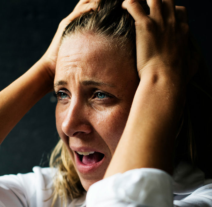 Woman looking stressed, holding her head, with focus on family pressure and parental role dynamics. Woman looking stressed, holding her head, with focus on family pressure and parental role dynamics.