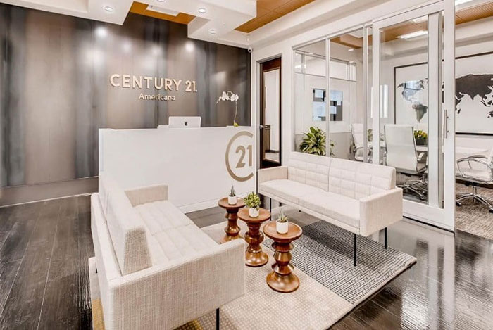 Real estate office lobby with modern furniture, featuring the Century 21 logo on the wall. Real estate office lobby with modern furniture, featuring the Century 21 logo on the wall.
