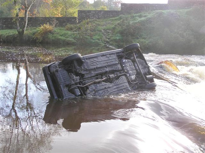 Overturned car in a river, highlighting life-saving awareness in emergencies.