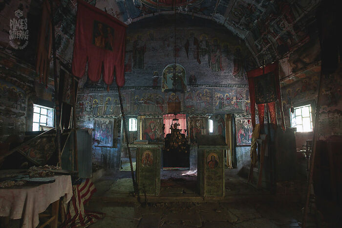 Eerie abandoned place with faded religious murals and dimly lit interior, creating a haunting atmosphere.