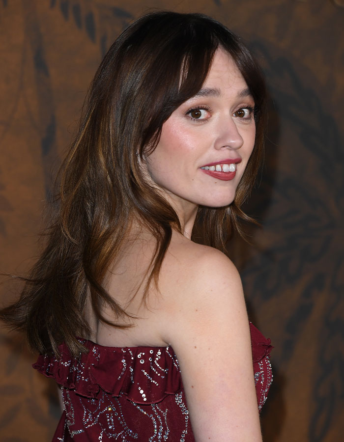 A person in a red dress at an event, smiling confidently, related to "The White Lotus" and embracing uniqueness. A person in a red dress at an event, smiling confidently, related to "The White Lotus" and embracing uniqueness.