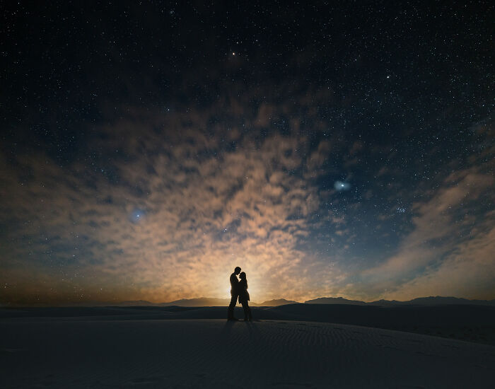 A couple embracing under a starry sky at dusk, highlighting one of the best engagement photos of 2025.