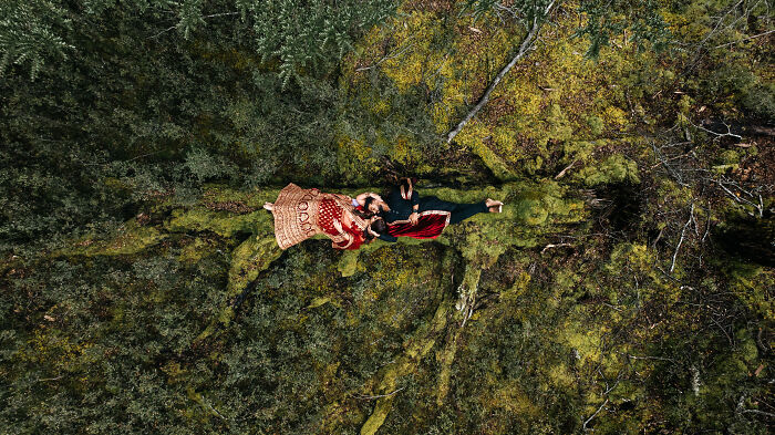 Couple lying on moss in forest, showcasing best engagement photography of 2025.