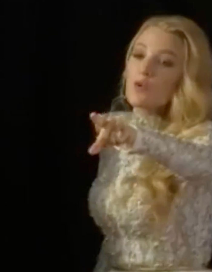 Blake Lively in a white lace dress, gesturing on the red carpet, sparking buzz. Blake Lively in a white lace dress, gesturing on the red carpet, sparking buzz.