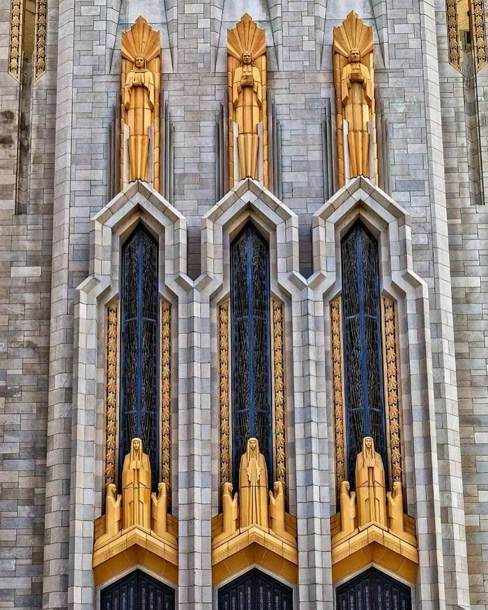 Art Deco facade with sculpted figures in gold, showcasing detailed American architecture design elements.