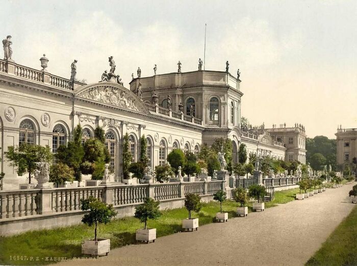 Elegant old architecture with ornate facade and lush gardens.
