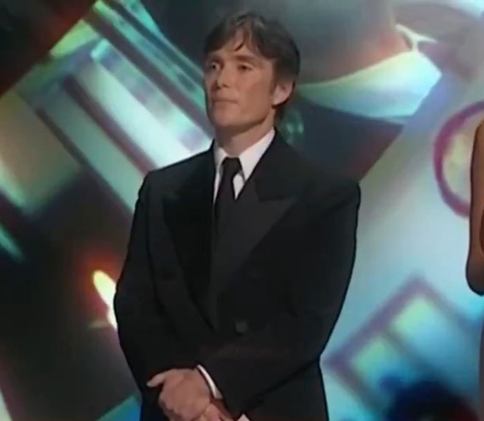 Man in a tuxedo standing during the Oscars, looking composed, related to viral Oscars speech moment. Man in a tuxedo standing during the Oscars, looking composed, related to viral Oscars speech moment.