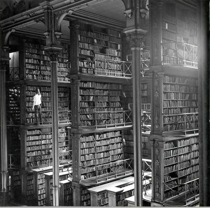 Historic American library with towering bookshelves and ornate ironwork, showcasing stunning architecture.