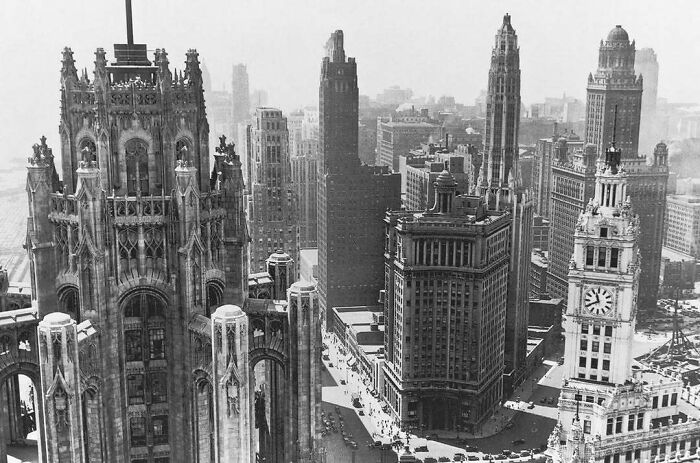 Vintage view of American architecture featuring iconic skyscrapers and historic buildings in a bustling cityscape.