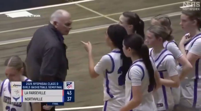 High school basketball coach interacting with players during a game on the court. High school basketball coach interacting with players during a game on the court.