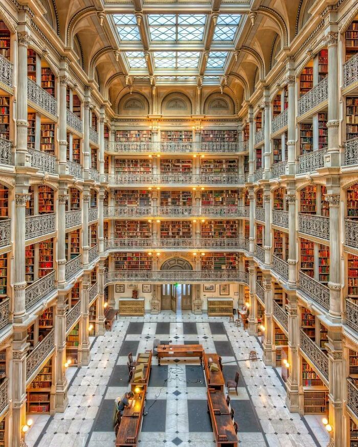 Historic American architecture: grand library interior with multiple book-filled levels under a skylighted ceiling.