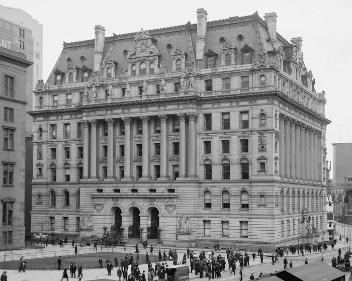 Historic American architecture with ornate façade and columns in a bustling city scene.
