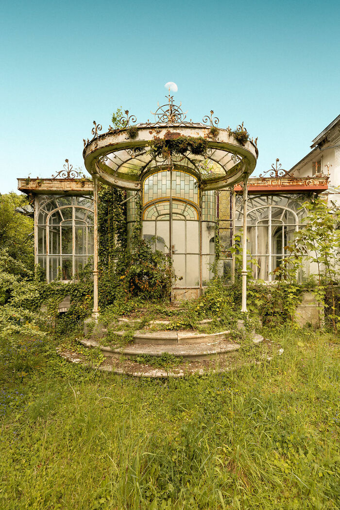 Abandoned building overgrown with vines and plants, showcasing nature's beauty reclaiming space over time.