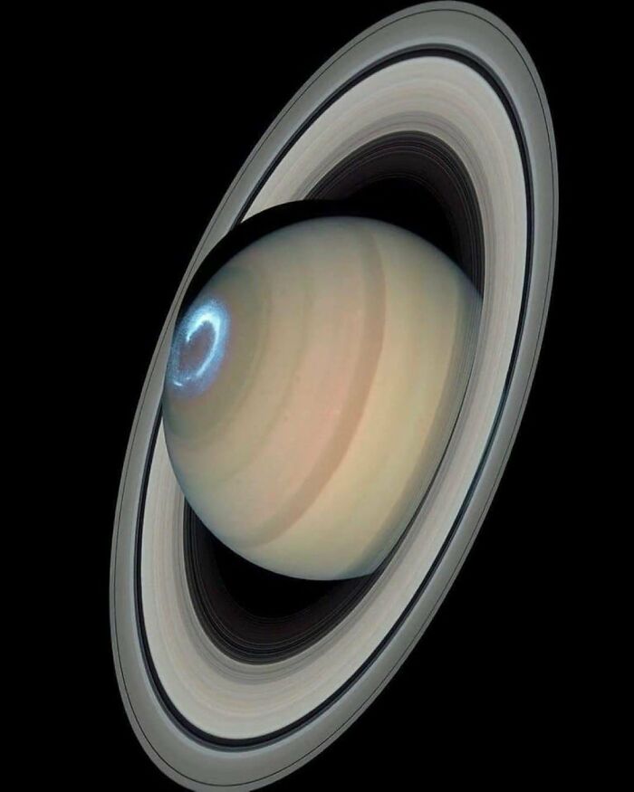Saturn with its rings and glowing auroras, showcasing stunning space phenomena.