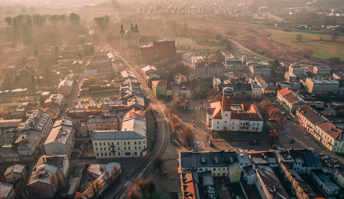 Aerial view of my city with historic buildings and streets, bathed in warm sunlight.