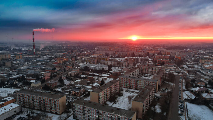 Aerial view of a cityscape at sunset with colorful sky and buildings, featuring the keyword "city from above".