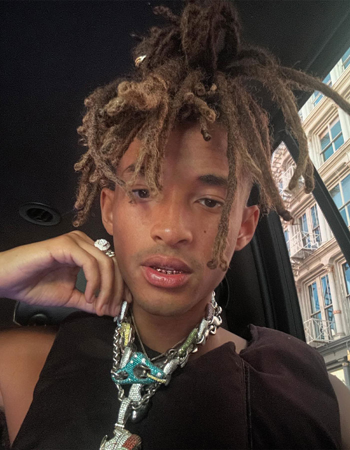 Young man with dreadlocks wearing a large chain necklace and a black top in a car. Young man with dreadlocks wearing a large chain necklace and a black top in a car.