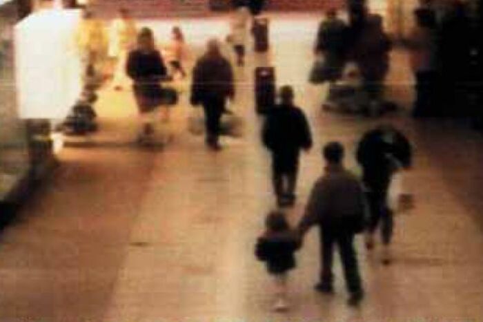 Blurry figures walk through a mall, creating eerie and unsettling context with a dark history, evoking a creepy atmosphere. Blurry figures walk through a mall, creating eerie and unsettling context with a dark history, evoking a creepy atmosphere.