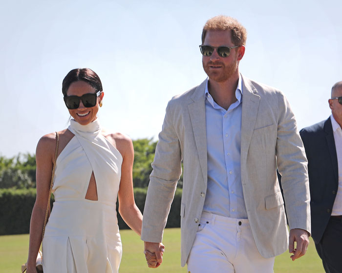Prince Harry and Meghan at a polo event, both in sunglasses and summer attire, walking together outdoors. Prince Harry and Meghan at a polo event, both in sunglasses and summer attire, walking together outdoors.