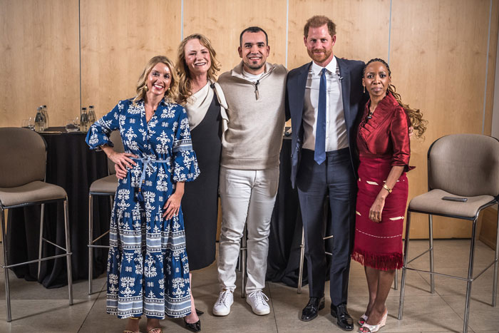 Group of five people at a charity event, including a man in a suit, standing together and smiling. Group of five people at a charity event, including a man in a suit, standing together and smiling.