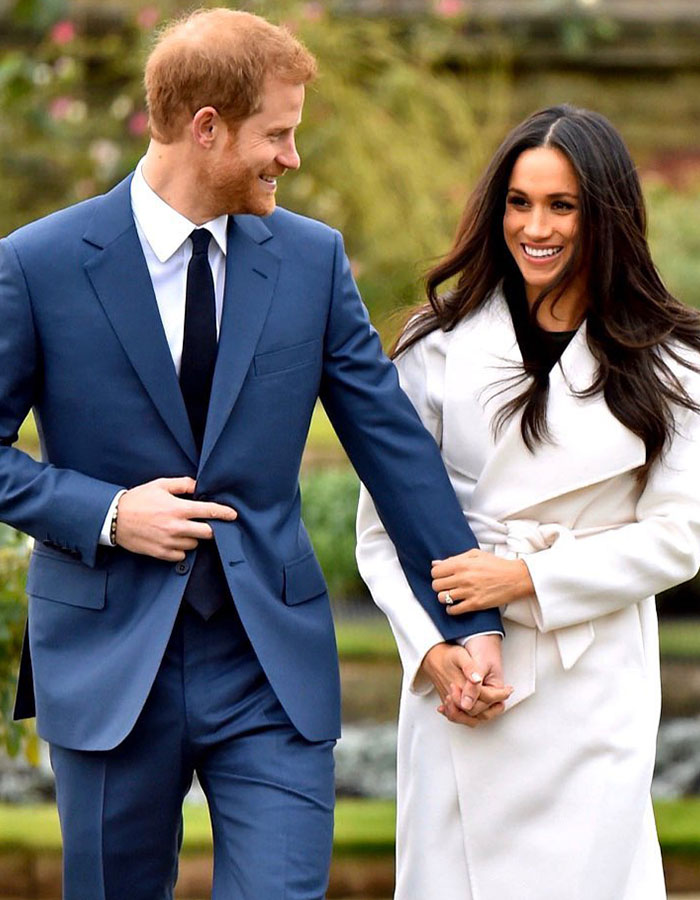 Couple smiling and holding hands, wearing formal attire outdoors, representing a public figure's charity event. Couple smiling and holding hands, wearing formal attire outdoors, representing a public figure's charity event.