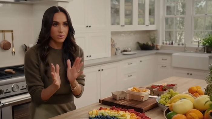 Meghan Markle in a kitchen discussing a project with assorted fruits, related to her work on a Netflix show. Meghan Markle in a kitchen discussing a project with assorted fruits, related to her work on a Netflix show.