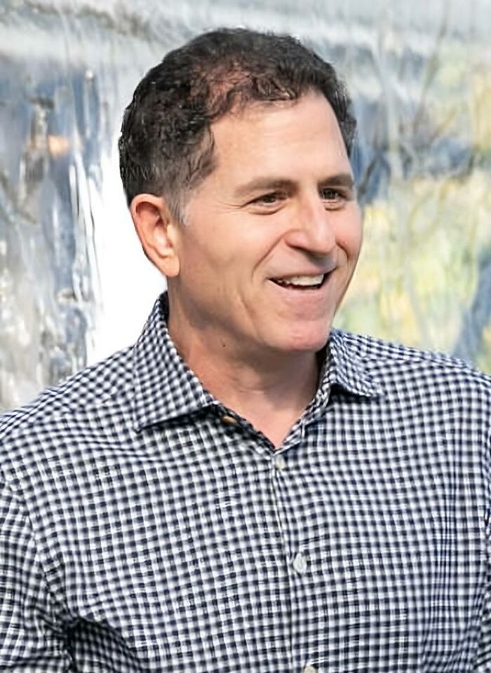 Man in a checked shirt smiling outdoors, representing the richest people in the world and their wealth compared to countries.