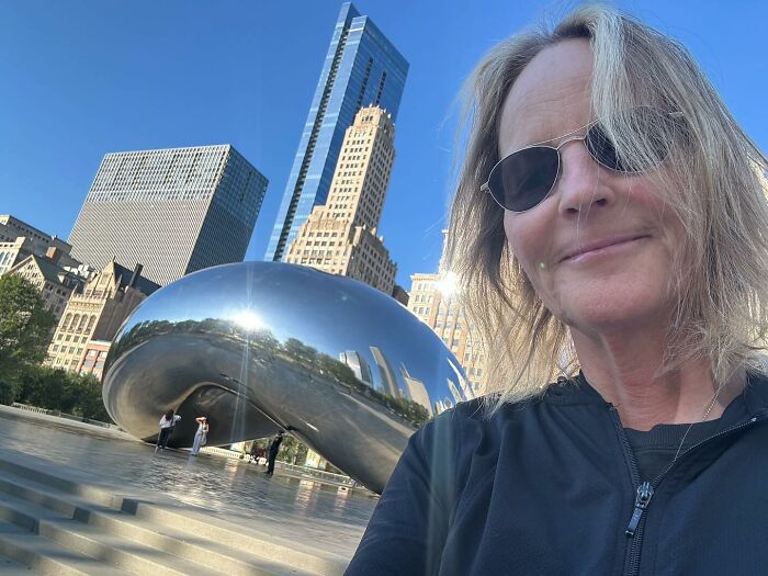 Reclusive actress in black jacket and sunglasses, with city skyline and reflective sculpture in the background. Reclusive actress in black jacket and sunglasses, with city skyline and reflective sculpture in the background.