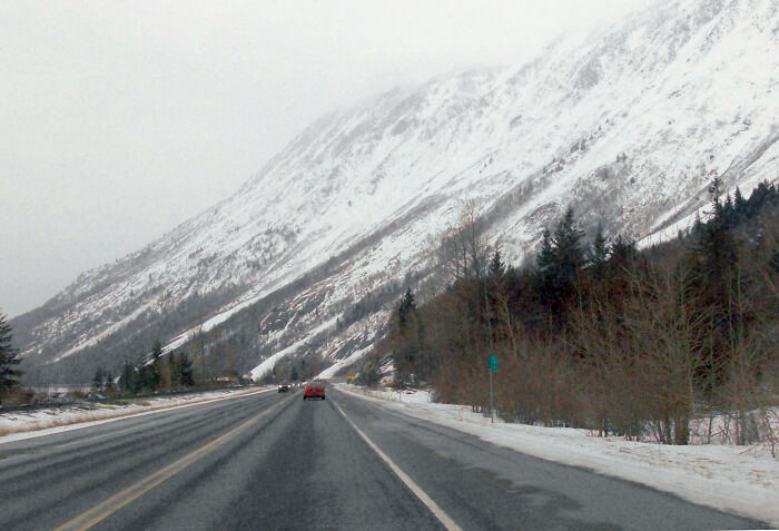 Snowy highway through mountains, showcasing legendary American road routes.