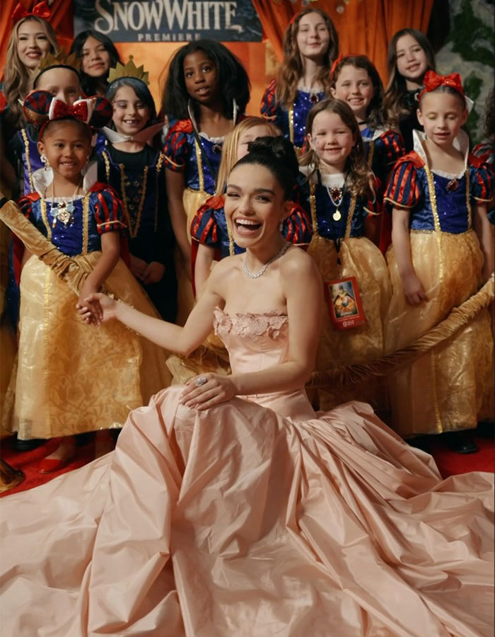 Actress in pink gown at Snow White premiere with children in costumes, reflecting Disney's "woke" Snow White theme. Actress in pink gown at Snow White premiere with children in costumes, reflecting Disney's "woke" Snow White theme.